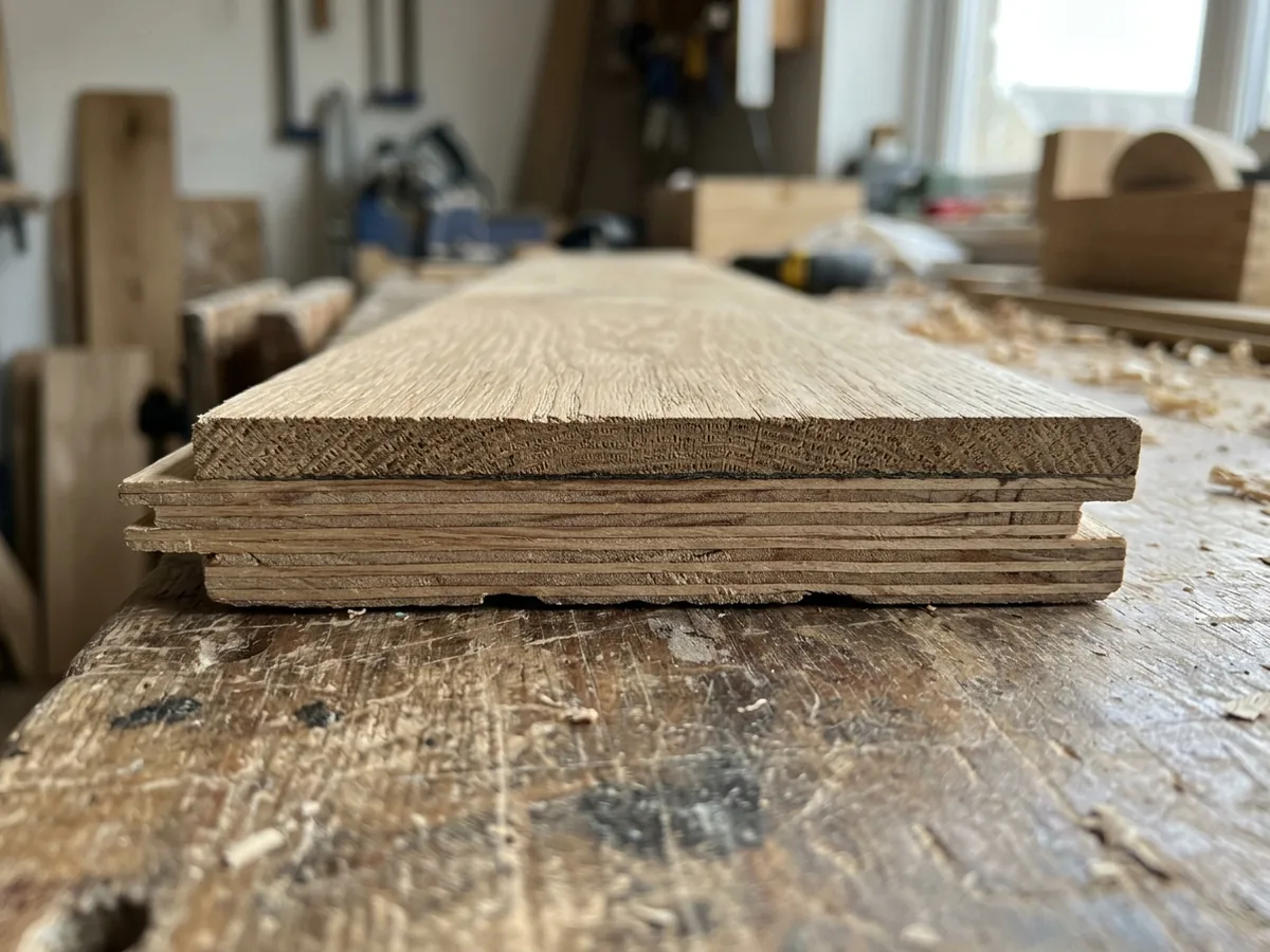 Edge of an engineered wide plank showing a thick oak wear layer over a cross-laminated plywood core